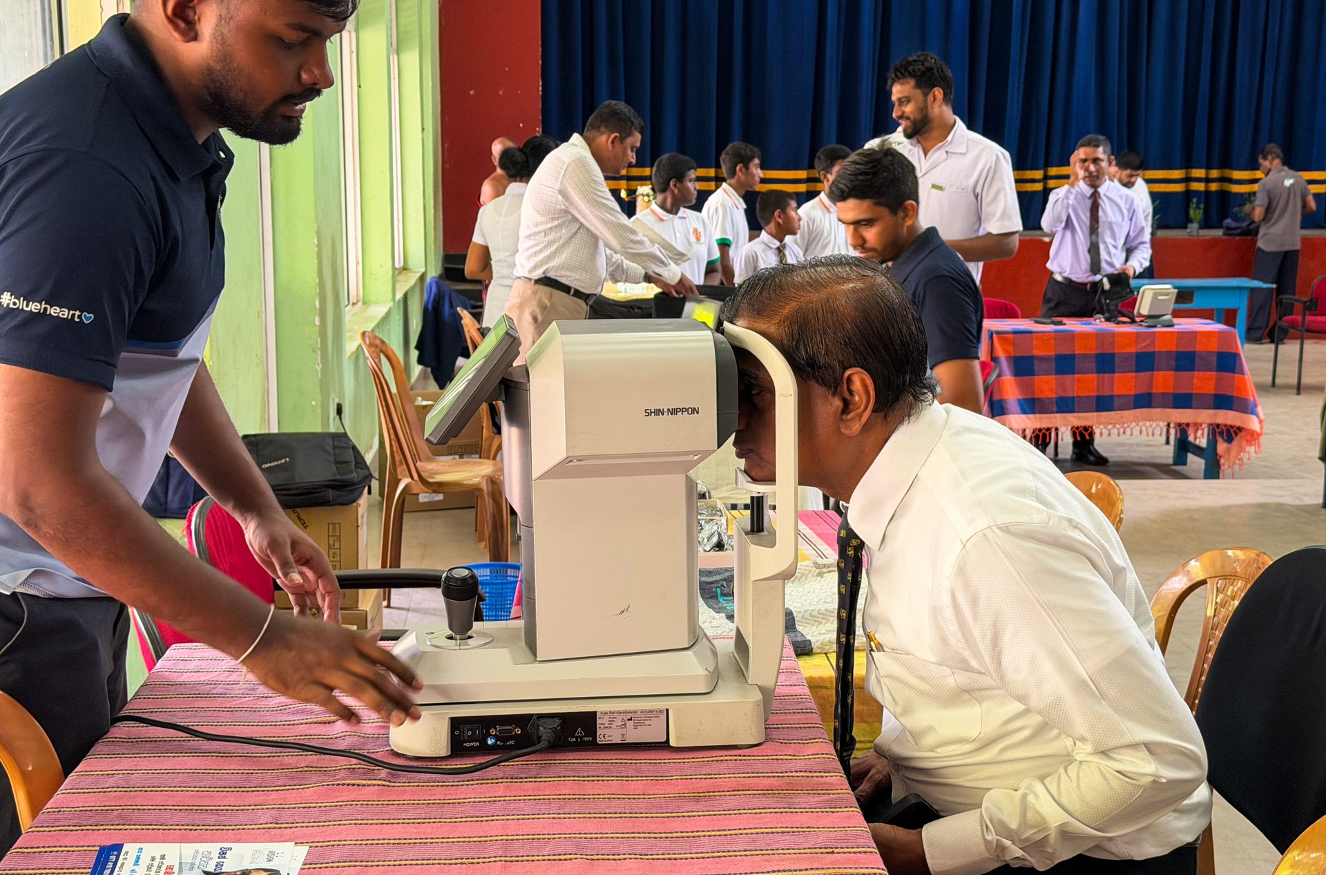 First Aid and Red Cross Society member assisting with an eye examination
